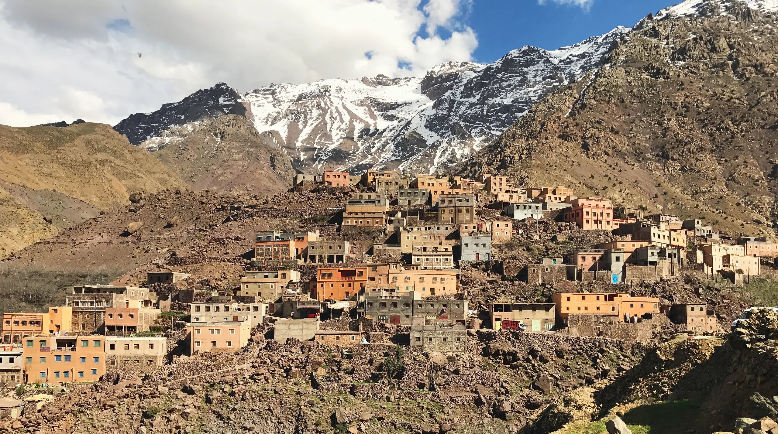 A village of stone houses in the Imlil valley below the snow-covered Toubkal massif