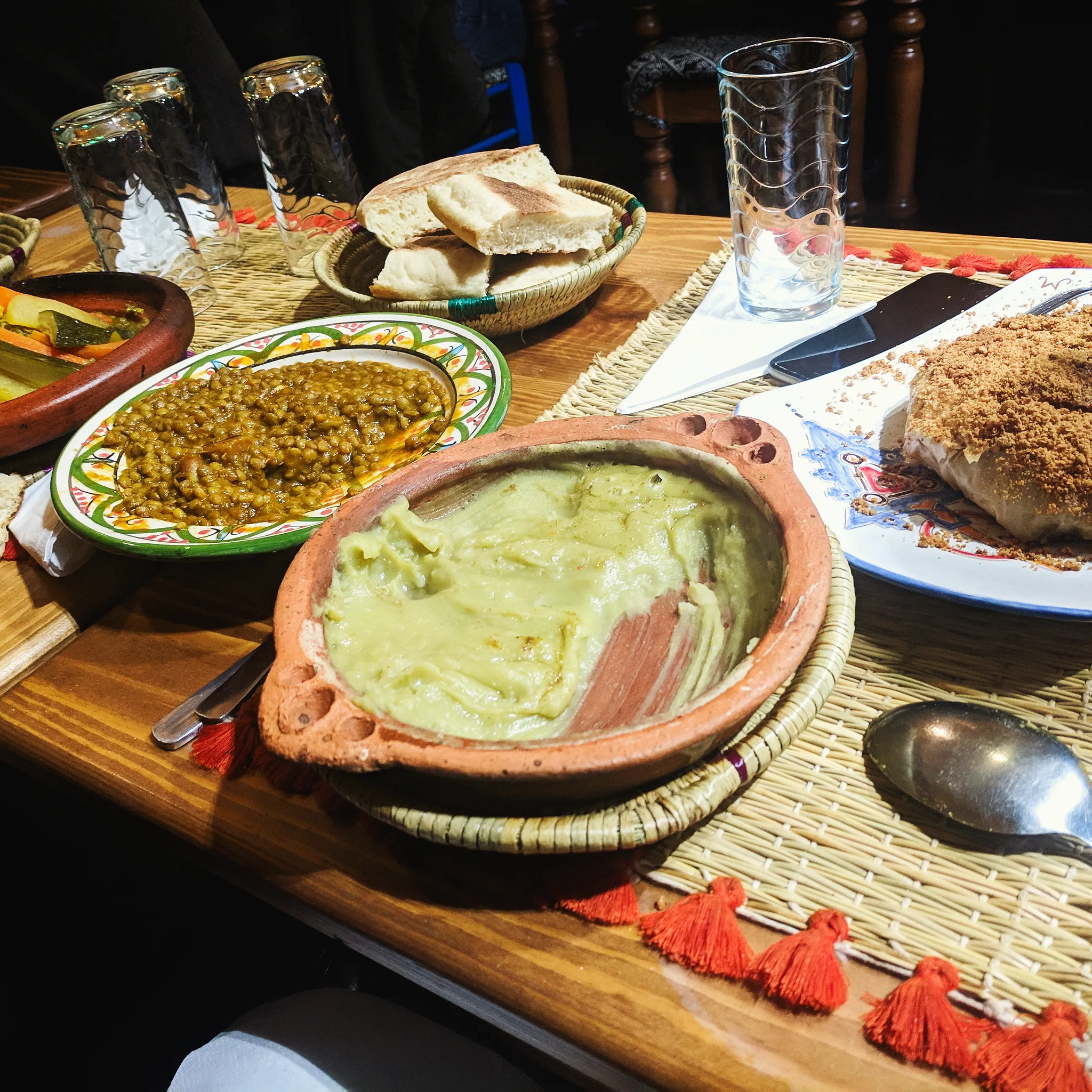 Traditional Moroccan cuisine flatlay with tagine, couscous, mint tea, and spices