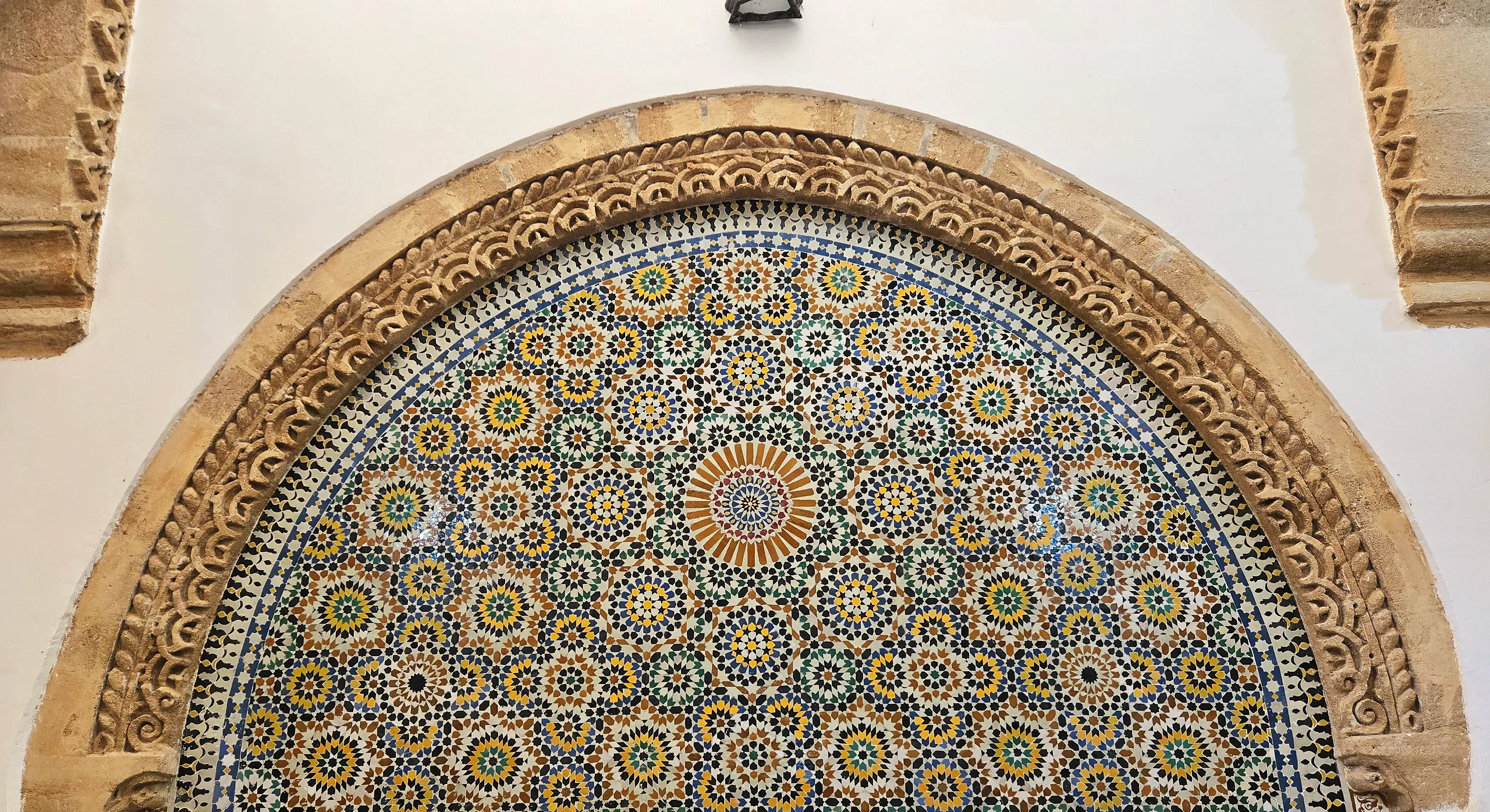 A tiled zellige fountain arch inside the Hammam Saffarin in Fes